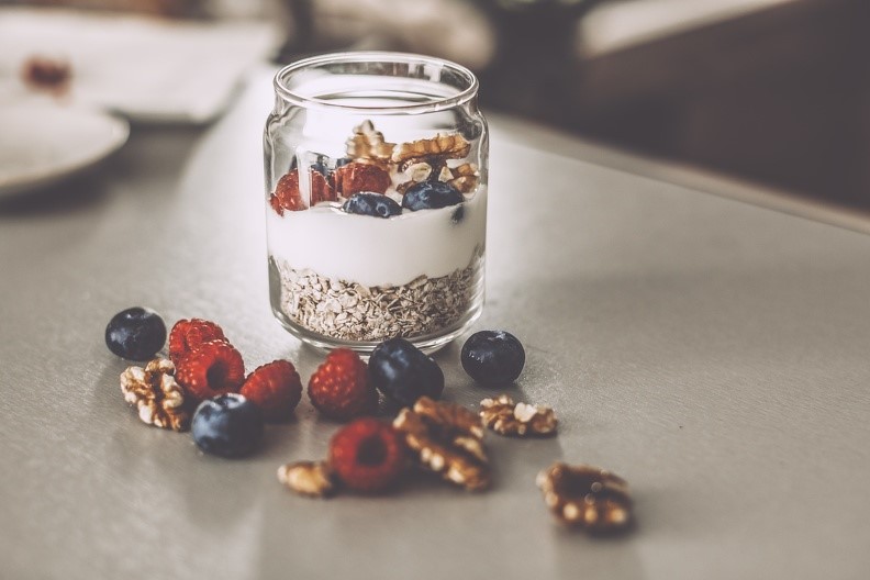 Glas mit Joghurt, Haferflocken, Walnüssen und Beeren