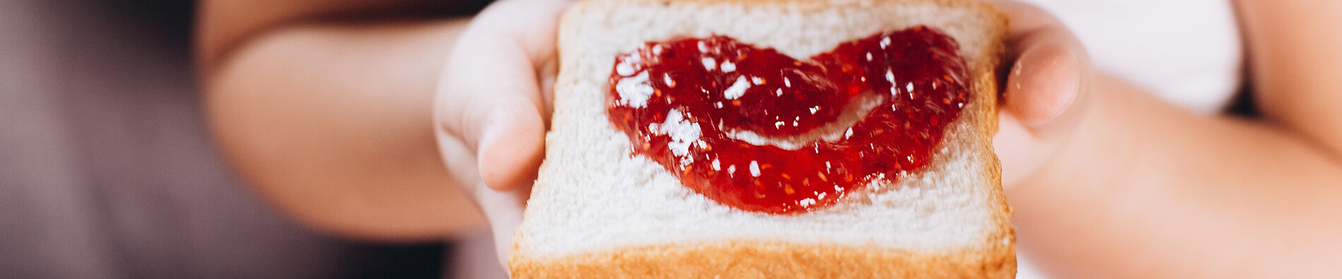 Children hand's holding sandwich with jam