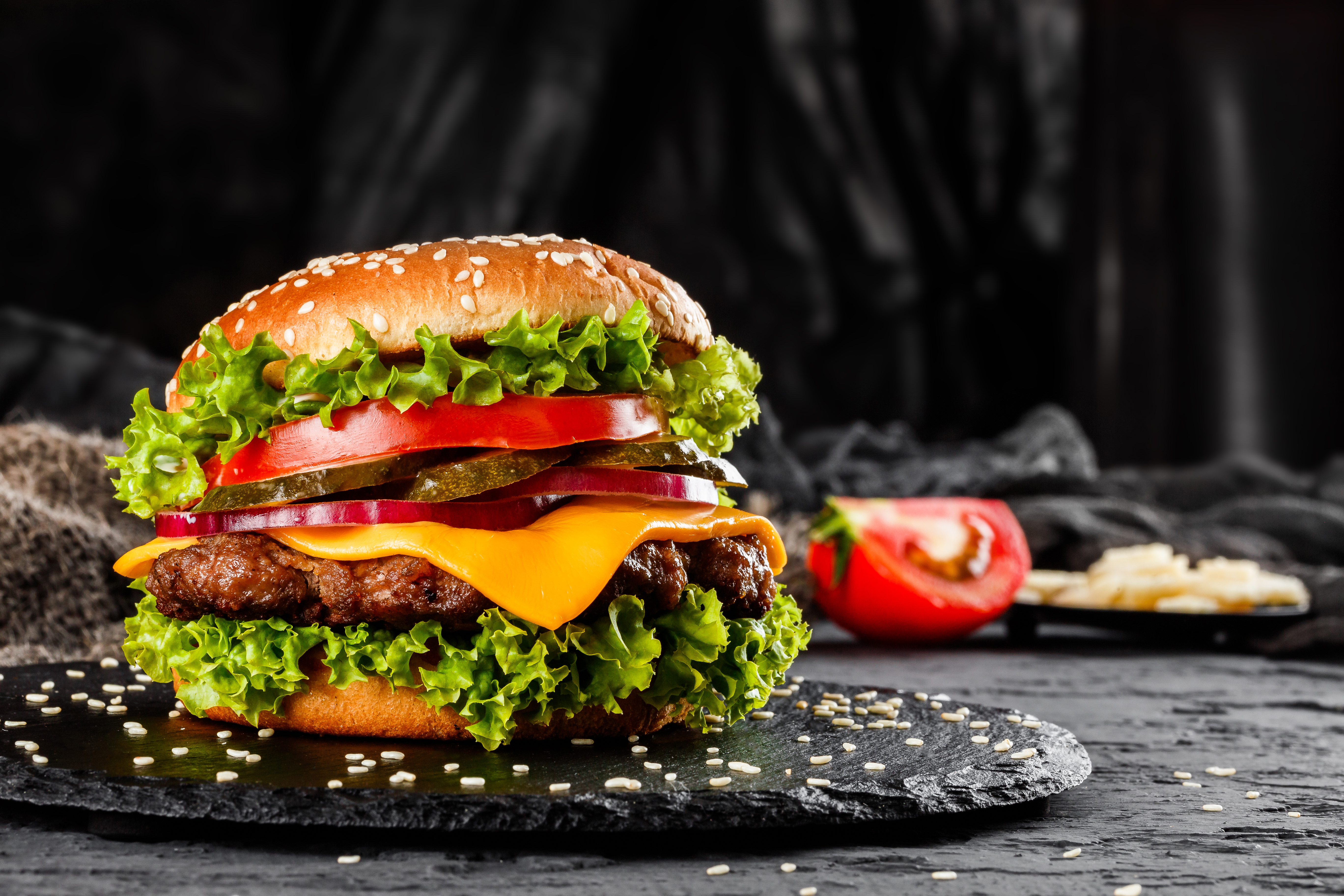 Burger with patty, salad, tomatos, cheese, pickles and ketchup