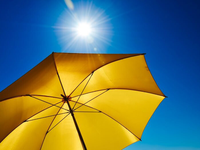 Yellow umbrella against blue sky