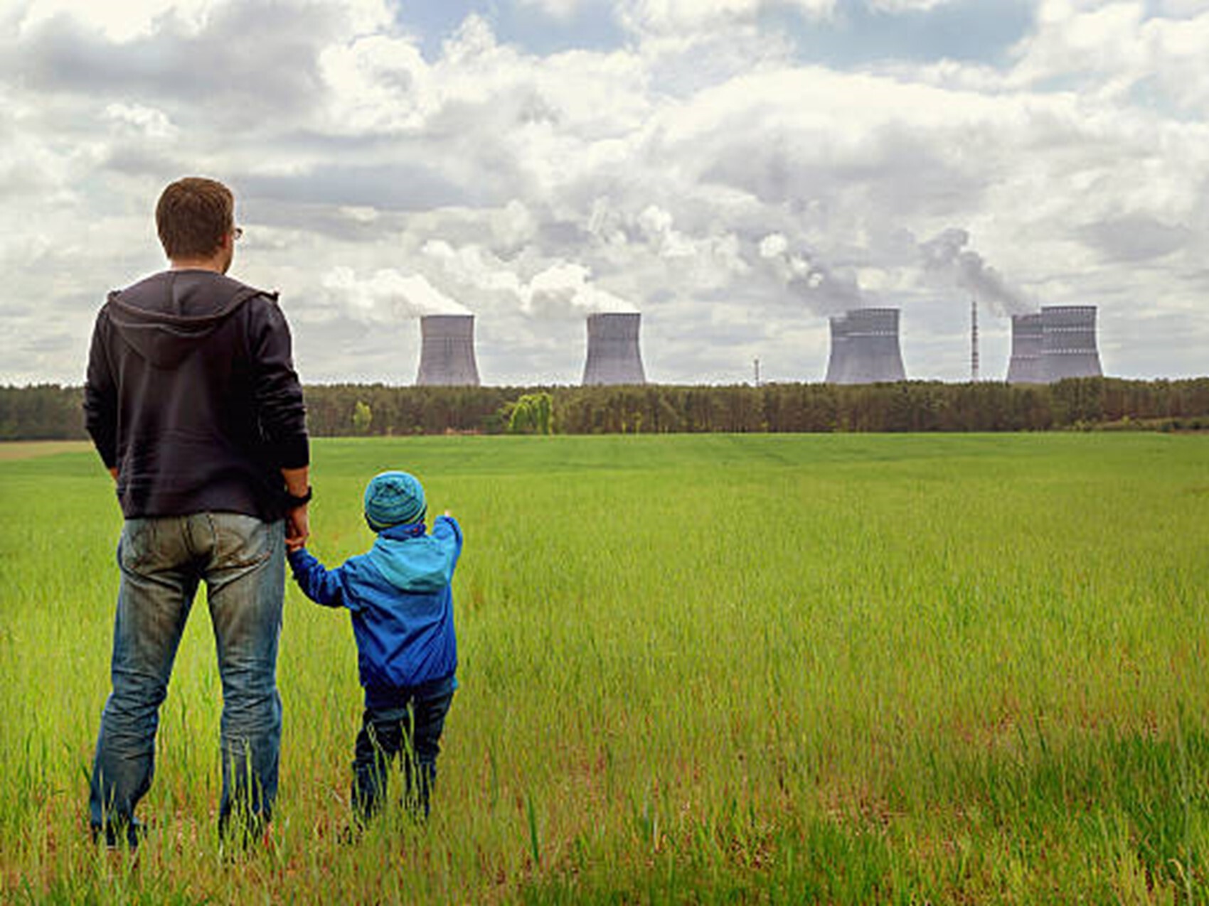 father and son standing in front of power stations