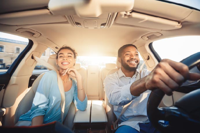 A woman and a man sitting in a car